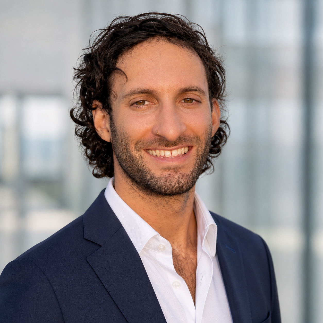 Sam DeNicola smiling in a navy blazer and white shirt